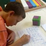 child studying math problems on ruled paper 2