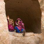 Two young girls sitting in a rock hole.