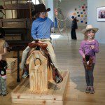 cowboy riding a saddle on a wooden platform