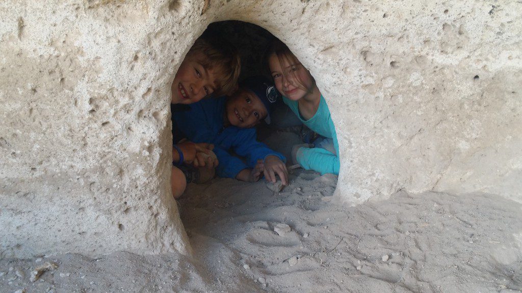 children hiding inside rock formation and sand