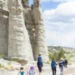 children walking on hiking trail with white canyon formation